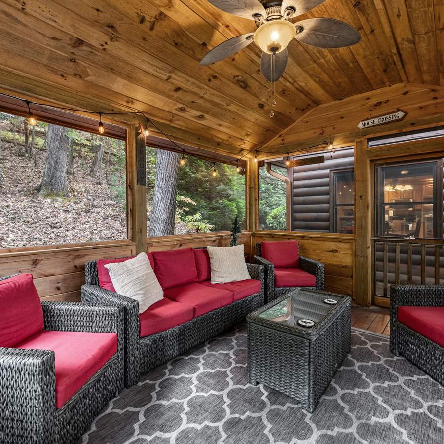 Screened porch with red-cushioned wicker seating