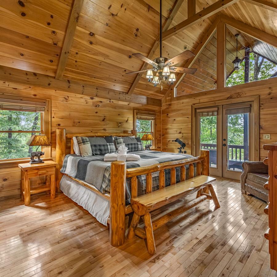 Upper king suite with a log bed under the cathedral ceiling